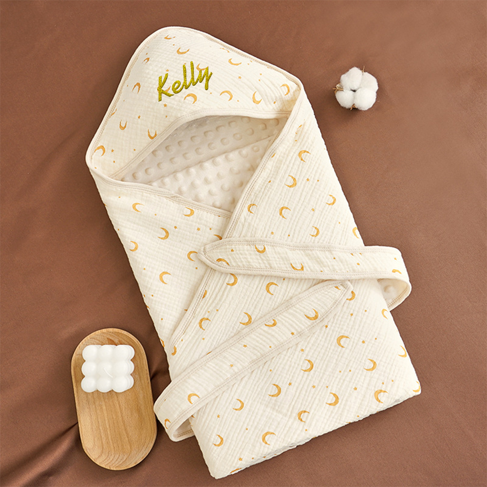 Flat lay of the swaddle blanket highlighting embroidery and soft texture