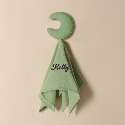 Personalised baby towel photographed with measuring guide to show 15in x 15.75in size, embroidered name detail included