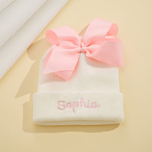 Personalised knitted baby hat with bow — custom name embroidery on soft polyester yarn, suitable for newborns and toddlers (48–54 cm)