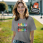 Flatlay of personalised crayon teacher T-Shirt folded to display the colourful crayon graphic and custom name – thoughtful personalised teacher gift for Back to School