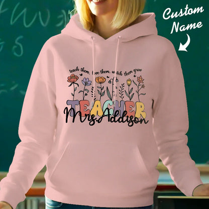 Teacher wearing the personalised wildflower hooded sweatshirt in a casual classroom scene — stylish back-to-school teacher gift with custom name