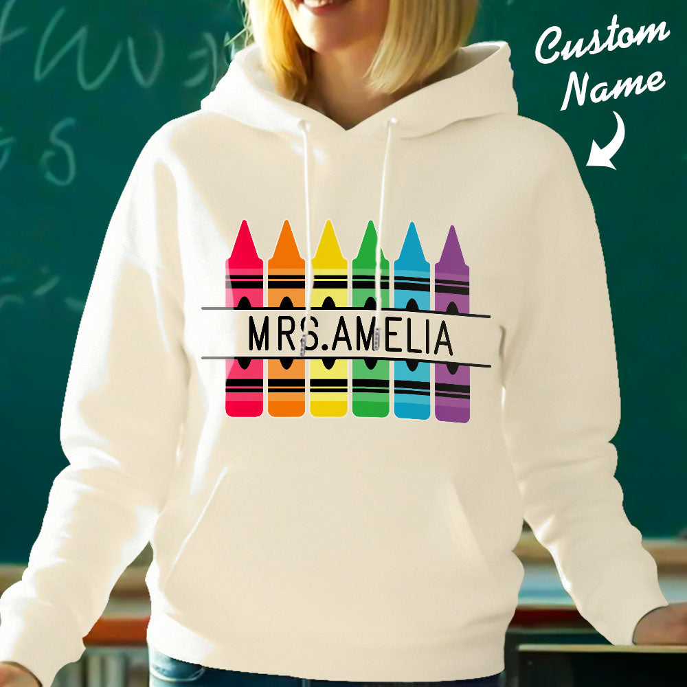 Close-up of crayon-themed graphic and printed custom name on personalised hooded sweatshirt — vibrant colours for a thoughtful teacher gift