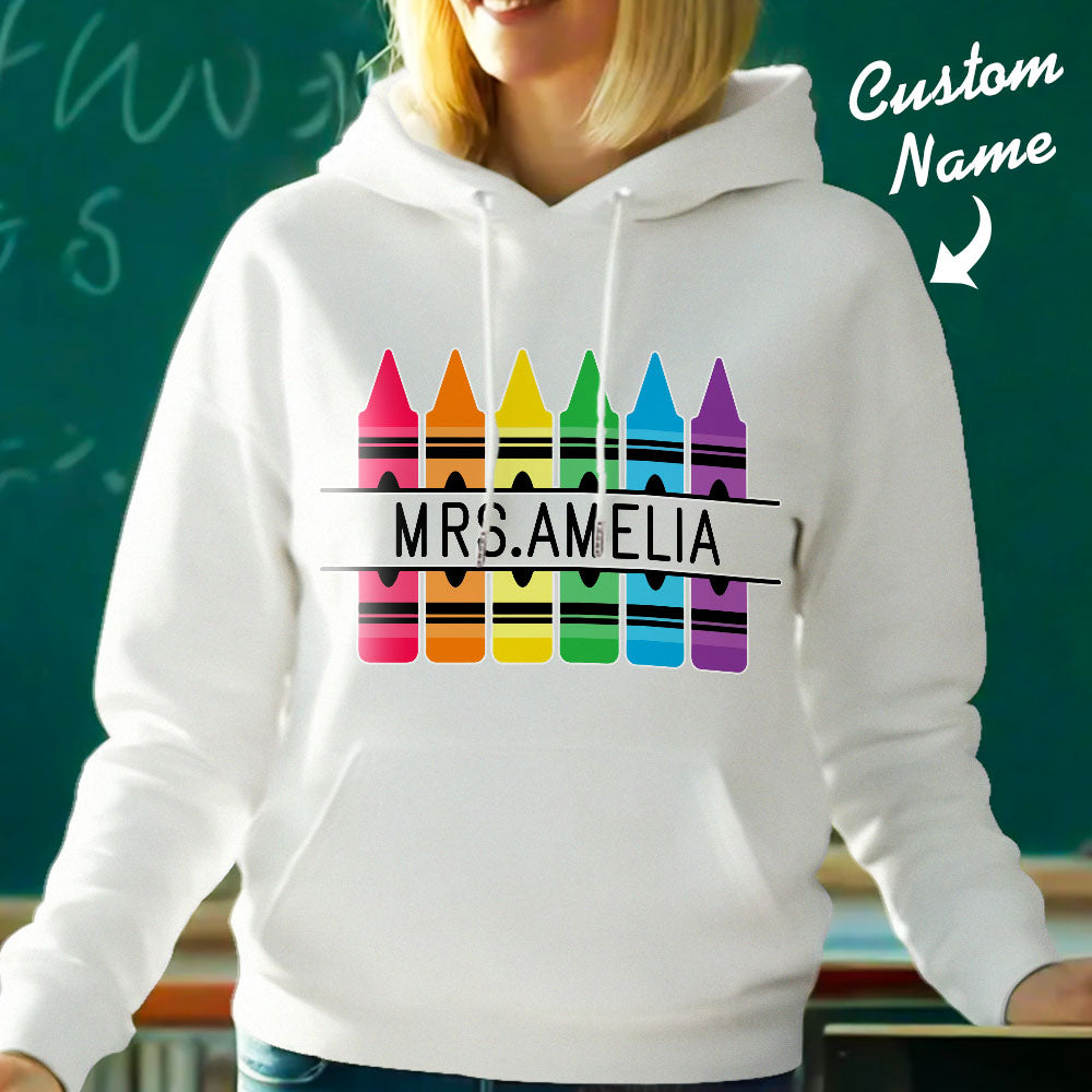 Flat-lay display of personalised crayon hooded sweatshirt with custom name — ready as a thank-you gift for teachers and mentors