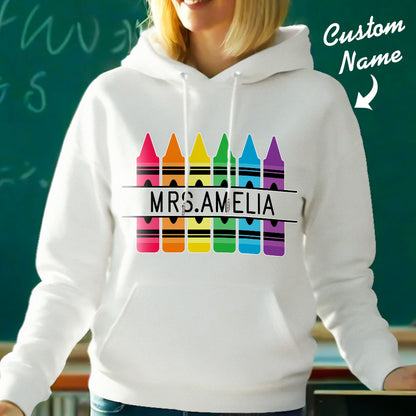Flat-lay display of personalised crayon hooded sweatshirt with custom name — ready as a thank-you gift for teachers and mentors