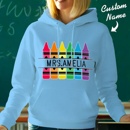 Personalised crayon hooded sweatshirt neatly folded and presented — ideal custom-name teacher gift or birthday present for school staff