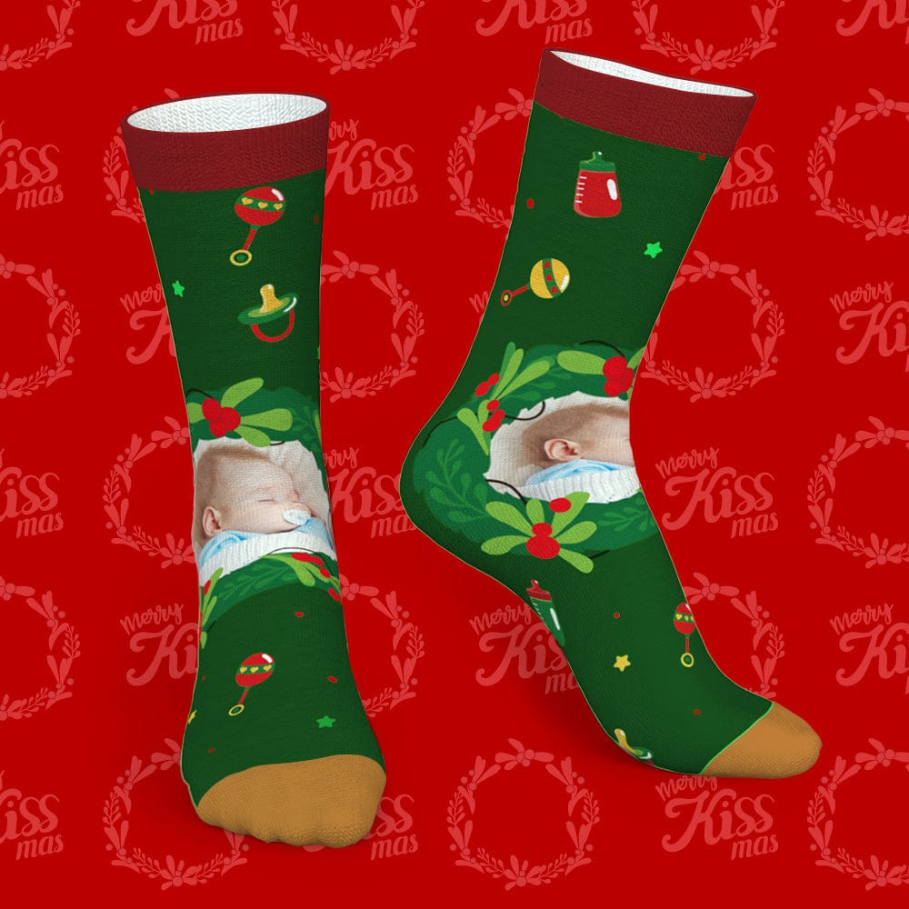 Flat lay pair of personalised photo socks showing custom photo area and festive mistletoe & feeding bottle motifs — great personalised stocking filler