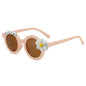 Angled view of personalised daisy sunglasses highlighting playful daisy motif and curved toddler frame with custom name option
