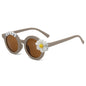 Close‑up of decorative daisy detail on the frame of personalised kids sunglasses — ideal toddler gift with custom name