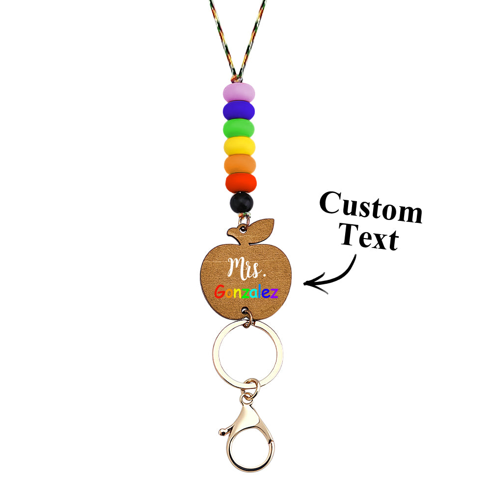 Colour variants of personalised wooden apple lanyards laid out — customisable teacher gifts with silicone beads