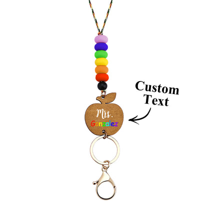 Colour variants of personalised wooden apple lanyards laid out — customisable teacher gifts with silicone beads