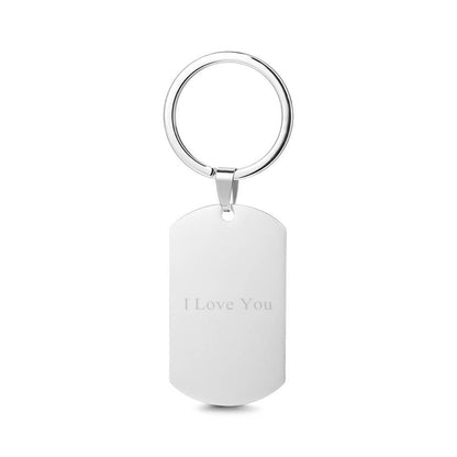 Close-up detail of personalised stainless steel photo tag showing crisp laser engraving of a portrait and clear custom text on a polished metal face