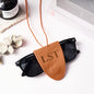 Macro shot of personalised initials engraved on leather travel glasses lanyard – crisp engraving detail