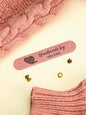 Custom PVC labels featuring engraved-style text ideal for knitted hats and scarves