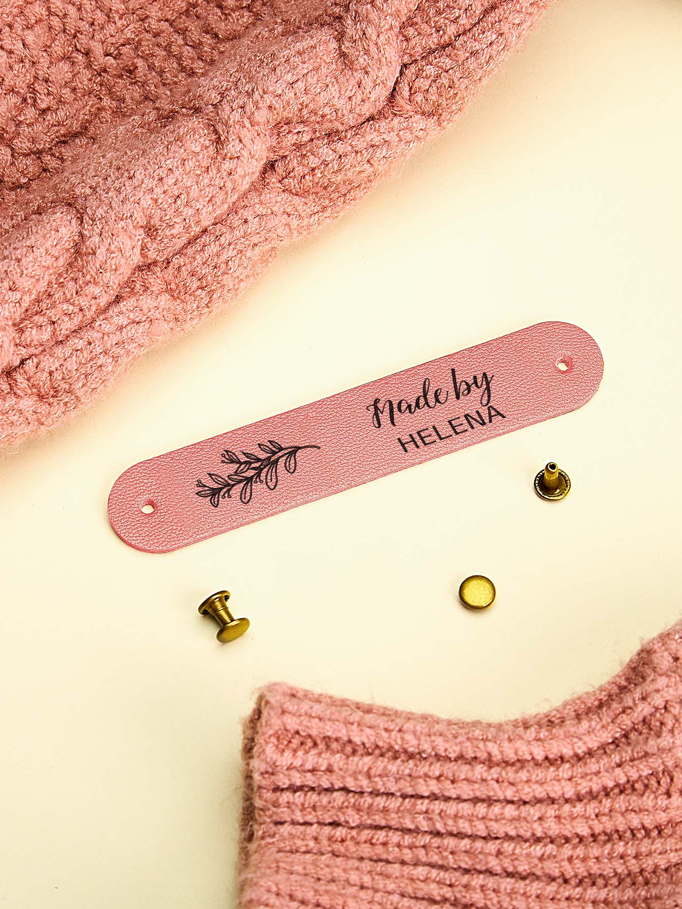 Personalised PVC labels on knitted babywear, petite custom branding for handmade gifts