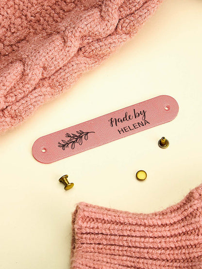 Personalised PVC labels on knitted babywear, petite custom branding for handmade gifts