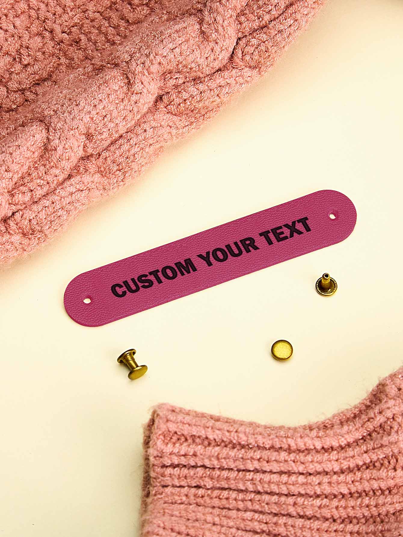 Custom PVC label attached to a handknit jumper — durable and washable personalised tag