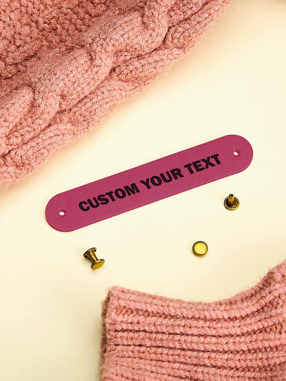 Custom PVC label attached to a handknit jumper — durable and washable personalised tag
