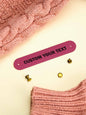 Custom PVC label attached to a handknit jumper — durable and washable personalised tag