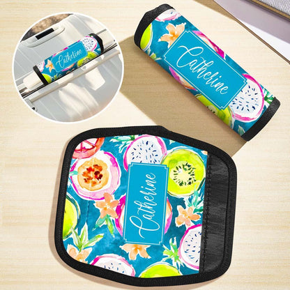 Stacked suitcases each fitted with a personalised neoprene handle wrap — handy for families and group travel