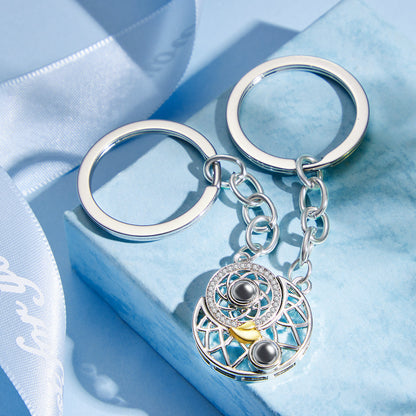 Hand-held Sun & Moon photo projection keyring in copper displaying sample projected image — thoughtful custom couple keepsake