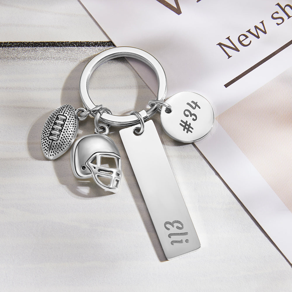 Close-up of custom engraved, hand-stamped football keychain showing detailed stamped name and ornate textured finish