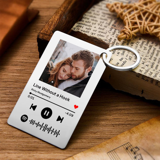 Personalised Spotify Code Keychain with engraved photo and song details on stainless steel plaque, close-up of scannable code