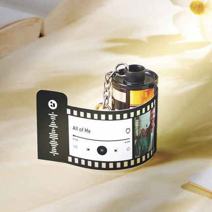 Close-up of personalised camera roll keychain with engraved name and date on durable recycled plastic — custom gift for Dad