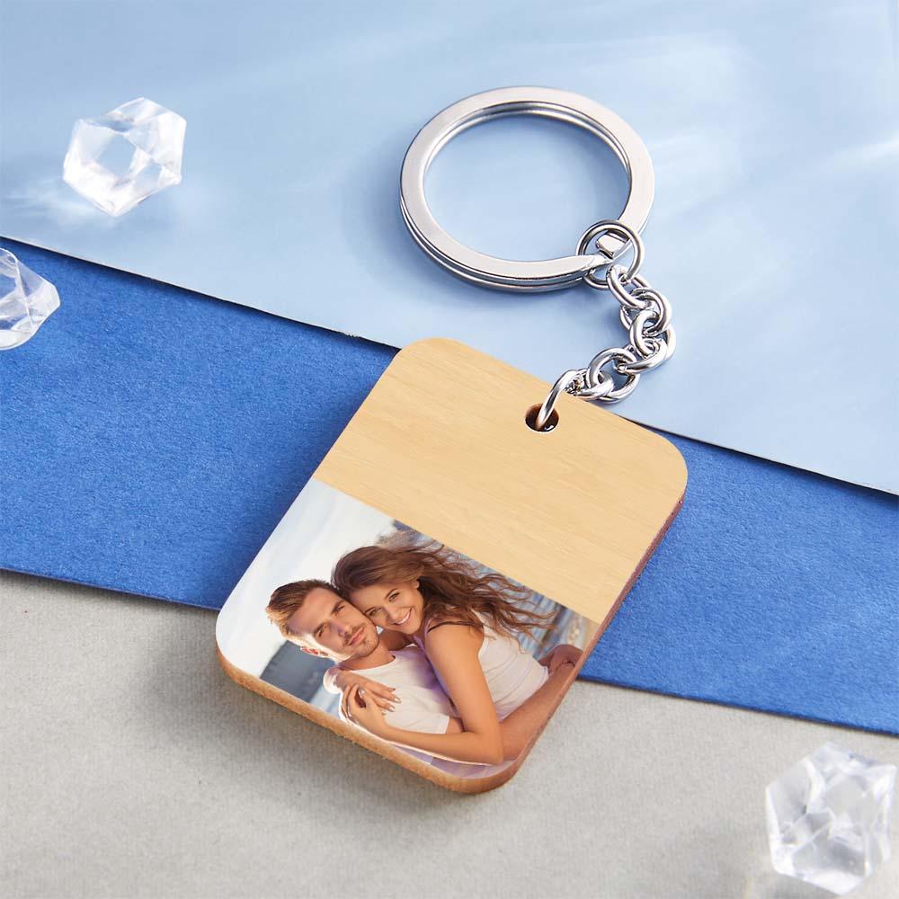 Close-up of personalised wooden photo keyring showing engraved custom text, natural wood grain and sturdy metal ring