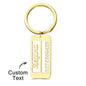Close-up of a personalised emergency contact keyring showing engraved text on the metal surface.