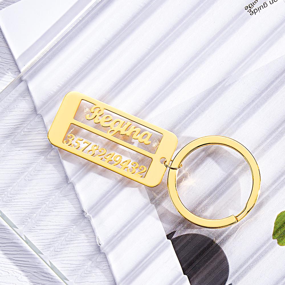 Personalised emergency contact keyring with engraved name and phone number beside keys.