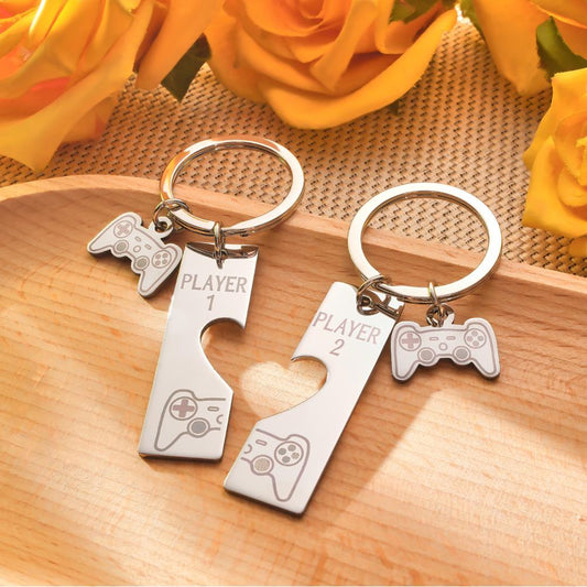 Pair of custom engraved game console keyrings on white background — personalised matching set for couples