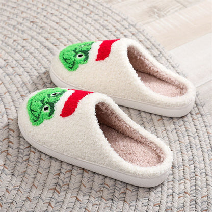 Top view of festive Grinch plush slip‑ons showing open‑mouth design and soft skin‑friendly fabric