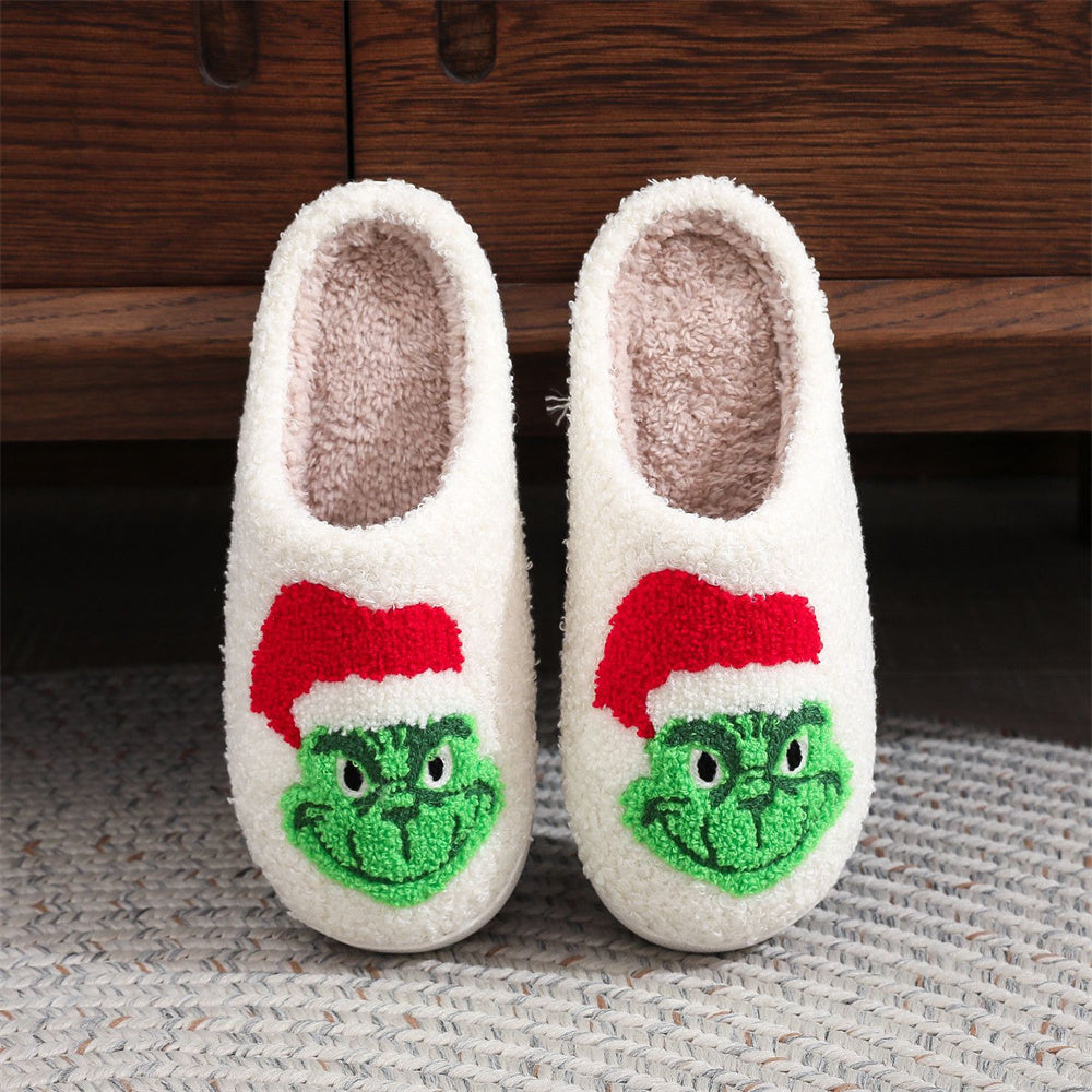 Model wearing cosy Grinch slip‑on slippers at home — perfect festive gift for family and seasonal photos