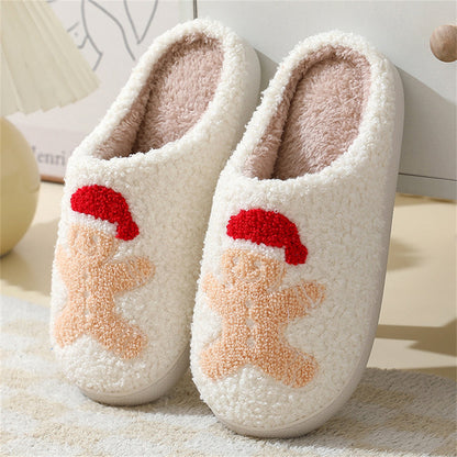 Side-angle of Santa and gingerbread plush slippers highlighting roomy slip-on shape and padded support for toes and heels