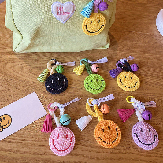Hand-knitted smiley face keyring close-up on metal ring — handmade crochet keychain in woollen yarn
