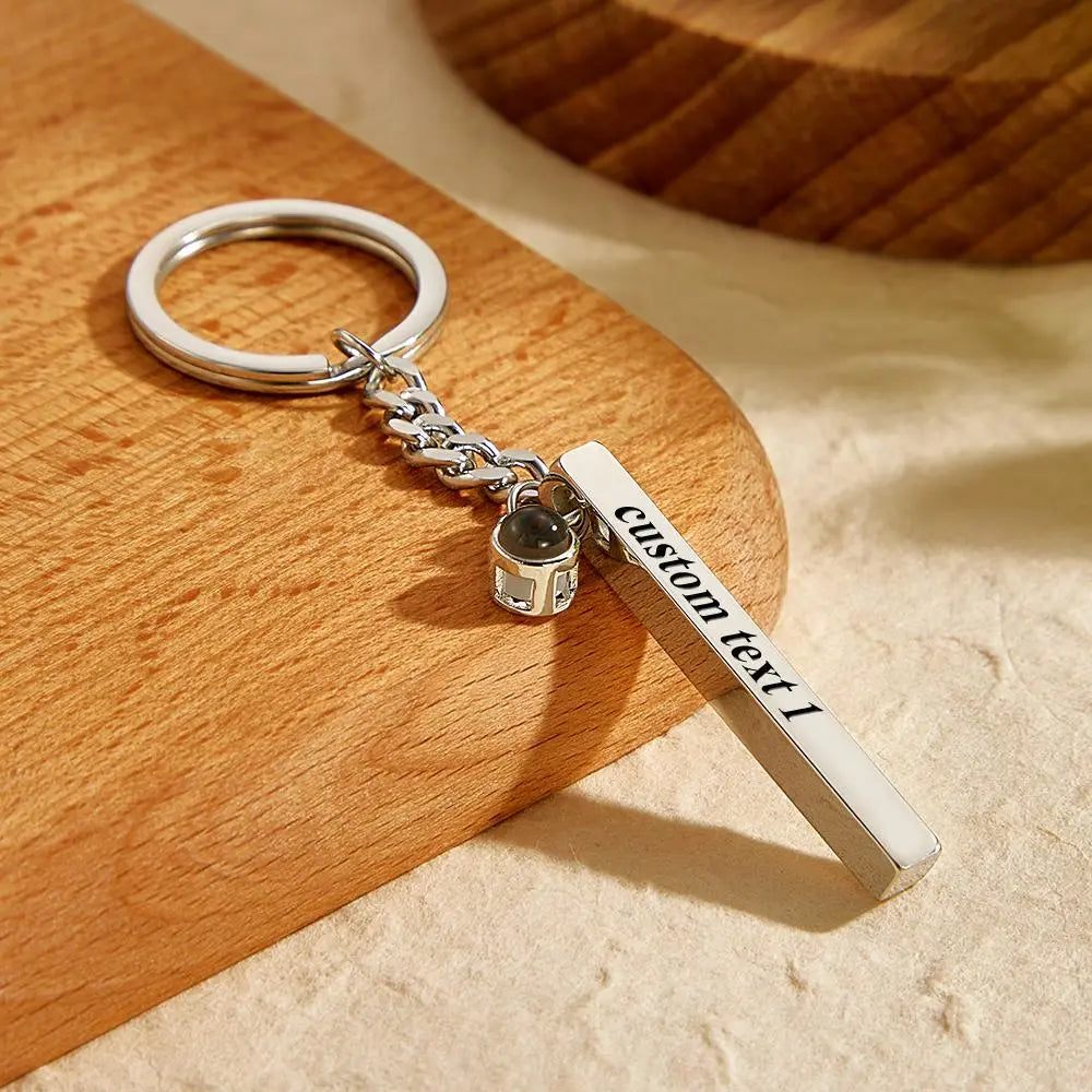 Polished engraved cube pendant photographed from above to highlight personalised text engraving and compact design – perfect personalised keychain gift