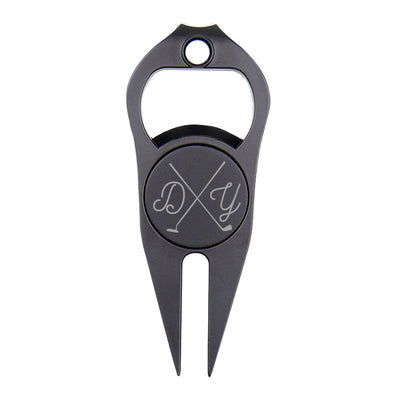 Close-up of personalised engraved magnetic ball marker and divot fork — golf accessory and bottle/can opener