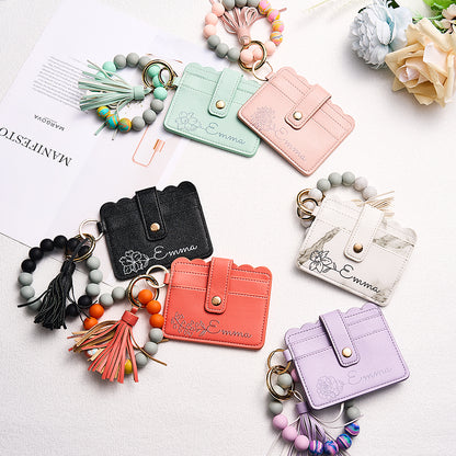 Close-up of detachable beaded bracelet and clasp detail on personalised birth flower card wallet, wearable wrist strap