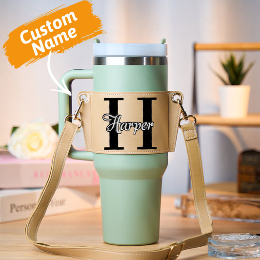Personalised PU leather carrier bag holding a 40oz Stanley tumbler with adjustable crossbody strap and custom name print