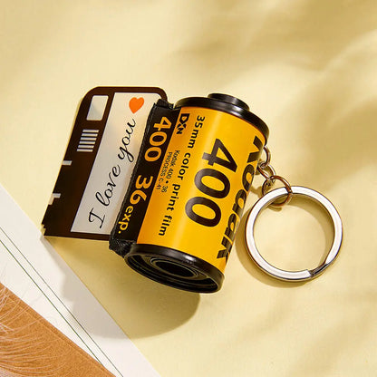 Detail shot of laser-cut edges and vivid colours on a personalised camera roll keyring with custom text and emoji options