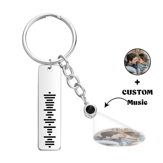 Personalised music code projection keychain close-up in polished silver titanium steel, custom projection keyring with laser nano‑engraved music code and metal split ring