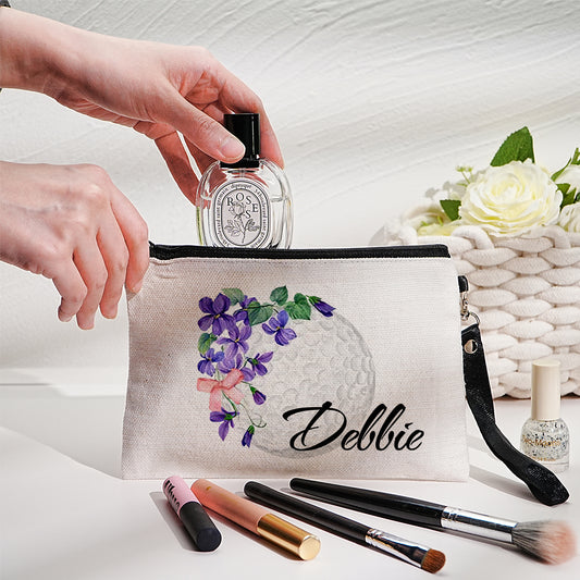 Personalised canvas makeup bag front view showing custom name, birth flower illustration and golf ball motif — durable travel cosmetics pouch with secure zip closure