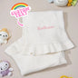 Close-up of embroidered name on a soft cotton knitted baby blanket.