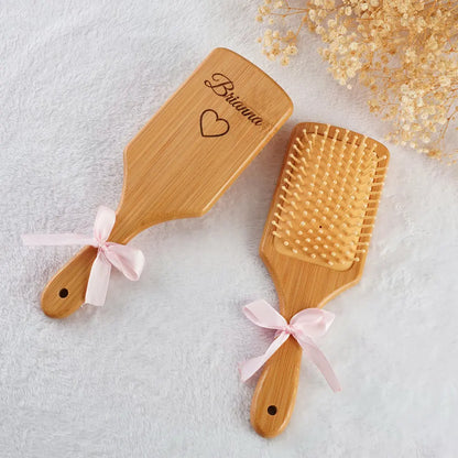 Close-up of custom engraved comb handle on a bamboo hairbrush showing personalised name – eco-friendly wedding keepsake for bridesmaids