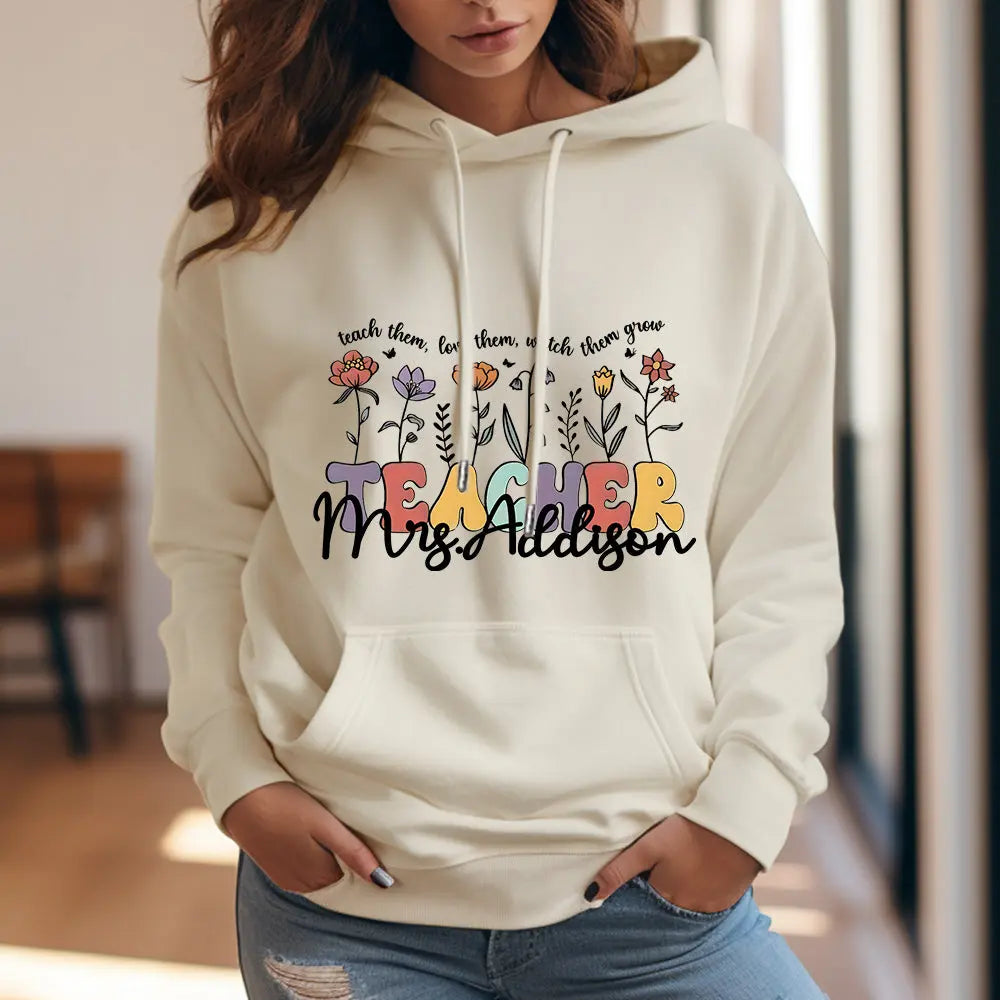 Close-up of the printed wildflower artwork and custom name on the hooded sweatshirt — high-resolution custom print for personalised gifts for teachers