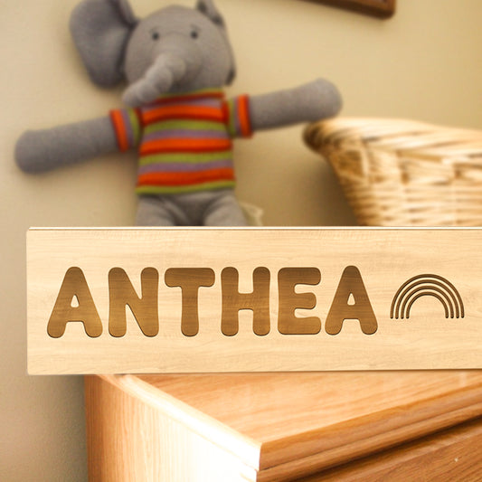 Personalised wooden night light with engraved name lit on a bedside, warm LED custom nursery night light and baby shower gift