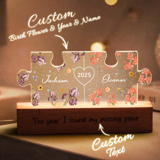 Personalised Couple Puzzle Night Light showing intertwined names and birth flowers laser-etched on gallery-grade acrylic with a sustainable wooden base, warm LED glow — custom name & birth flower LED gift for anniversaries