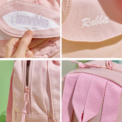 Mini rabbit backpack next to a children’s book to illustrate compact size, personalised embroidered name makes it a distinctive Easter, birthday or Christmas gift