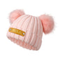 Side view of personalised baby beanie in pastel colour showing the custom name leather patch and stretchy acrylic knit