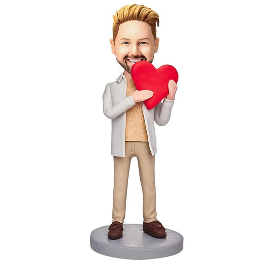 Personalised casual man bobblehead holding an engraved love heart handcrafted from polymer clay custom bobble head gift for anniversaries weddings birthdays ideal personalised keepsake UK Australia